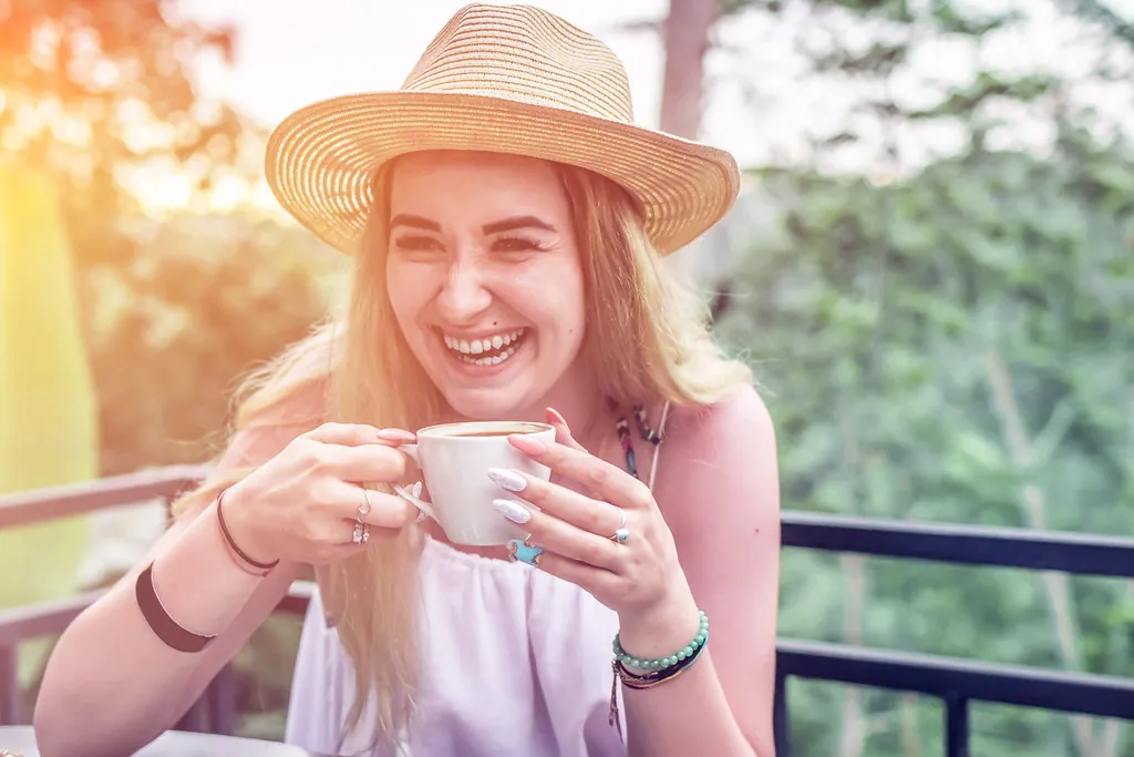Persona sonriendo mientras disfruta un café